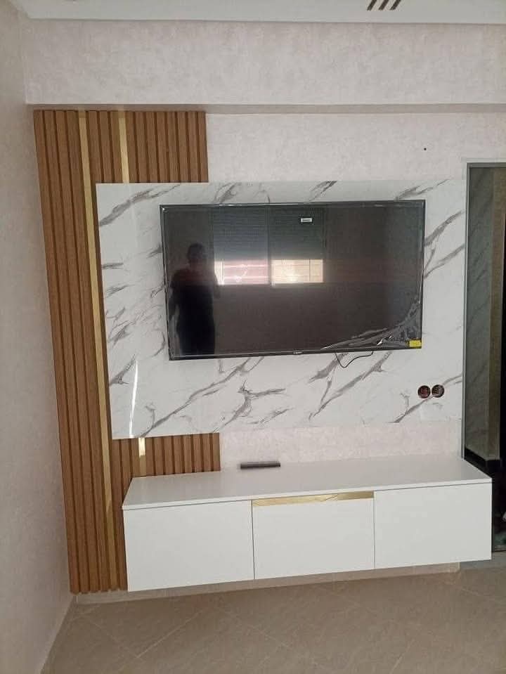 TV feature wall with built-in cabinetry and concealed lighting in a Doha living room (view 3)